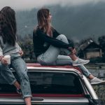 Communication Style - Two Women Sitting on Vehicle Roofs