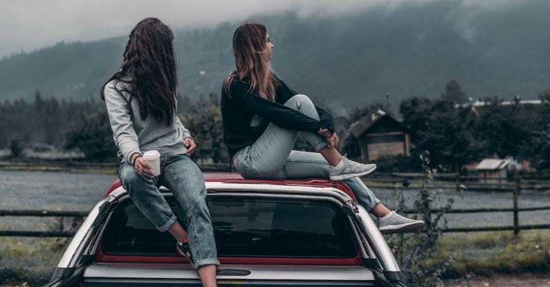 Communication Style - Two Women Sitting on Vehicle Roofs