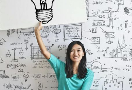 Business Idea - Woman Draw a Light bulb in White Board