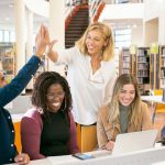 Collaborative Task Management - Cheerful multiethnic students having high five with teacher