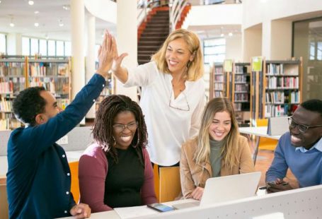Collaborative Task Management - Cheerful multiethnic students having high five with teacher