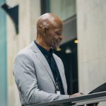 Board Of Directors - Cheerful African American manager reading documents in folder