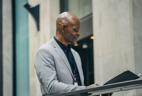 Board Of Directors - Cheerful African American manager reading documents in folder