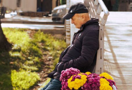 Solution Selling - A man sitting on a bench with flowers in his hand