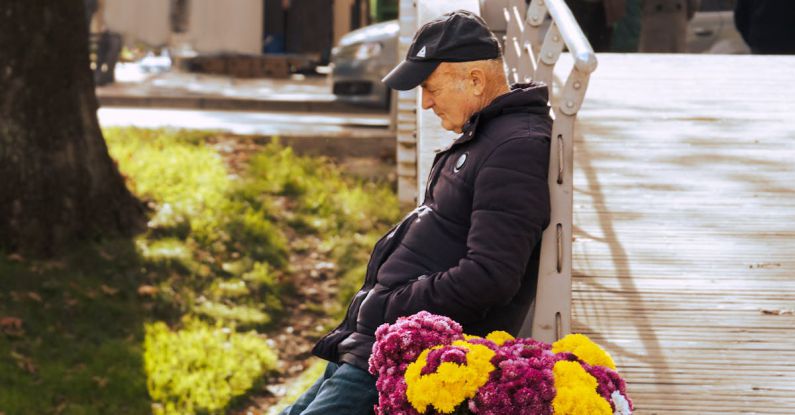 Solution Selling - A man sitting on a bench with flowers in his hand